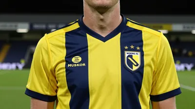 Woking FC's new 26-27 away kit features yellow with navy pinstripes and gold trim